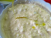 Dodajanje stopljenega masla mešanici rumenjakove kreme in beljaka.