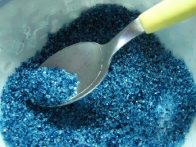 Iz sladkorja, ki sem mu dodala modro barvo v prahu in nekaj kapljic vode, sem naredila obarvan sladkor.